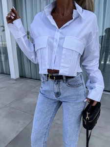 Détail d'une chemise blanche courte à manches longues avec deux poches à rabat et col polo