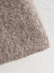 Close-up of wool texture and premium stitching on light brown winter coat fabric