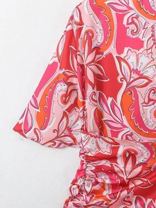Détail d'une robe imprimé paisley avec poignets évasés et taille froncée élégante