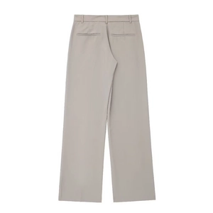 Détail du pantalon large taille haute beige clair avec poches arrière décoratives