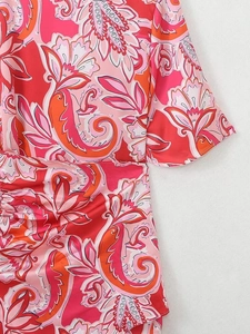 Gros plan sur le motif cachemire rose et orange vif sur le tissu de la robe mini