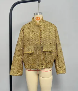 Detailed close-up of gold sequin tweed texture and flap pocket on a women jacket