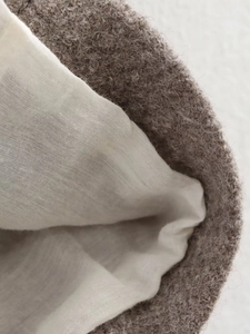 Macro shot of brown wool texture and light gray fabric lining on a winter coat