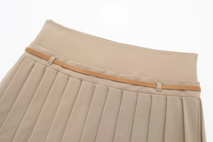 Dettaglio della gonna a pieghe kaki con sottile cintura in similpelle marrone e passanti