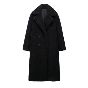 Détail d'un manteau noir en polaire teddy montrant le tissu épais et le col à revers