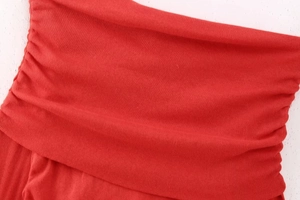 Close-up of red ribbed knit fabric texture showing detail of pleated off-shoulder top