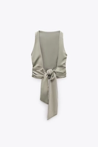 Detail of sage green satin top showing silk-like texture and waist tie-up design