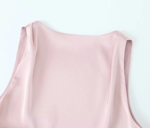 Detail of round neckline and smooth satin fabric texture on light pink sleeveless top