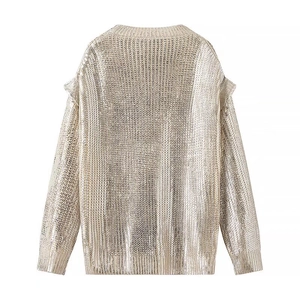 Detail of champagne gold metallic knit sweater featuring ruffled shoulders and ribbed cuffs