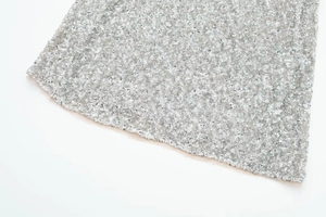 Close-up of silver sequin fabric detailing on an elegant sleeveless bodycon dress