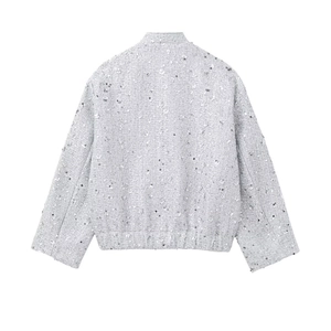 Detail view of the sequin-embellished back of a silver tweed jacket with elastic hem