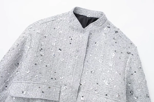Close-up of silver tweed jacket texture with shimmering sequins and stand-up collar details