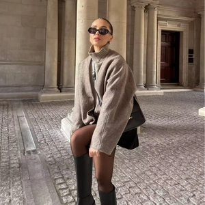 Women's chic oat-colored V-neck wool coat styled with boots in a street fashion look