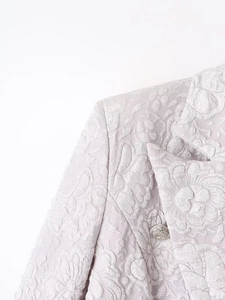 Detail of lilac floral textured blazer with silver lion head embossed metal button