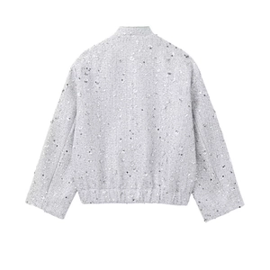 Detail of grey sequined tweed jacket back showing shimmering fabric texture and loose fit