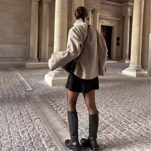Outdoor street view of a grey wool jacket paired with a black skirt and platform boots