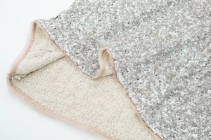Detailed close-up of shiny silver sequins and soft faux fur trim on a chic party dress