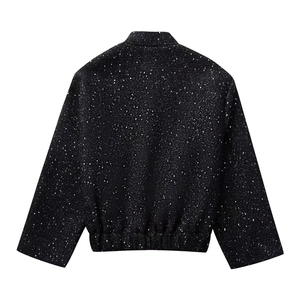 Close-up of black sequin jacket detail with shiny glitter texture and stand collar