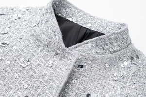 Macro shot of silver sequin tweed jacket collar with refined stitching and black lining
