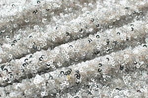 Detailed view of silver sequin fabric with metallic shimmer and elegant draped texture