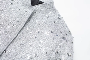 Detail of silver tweed jacket featuring sparkling sequins and delicate floral embroidery