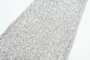 Detail of silver sequin fabric with metallic luster on elegant fitted summer dress