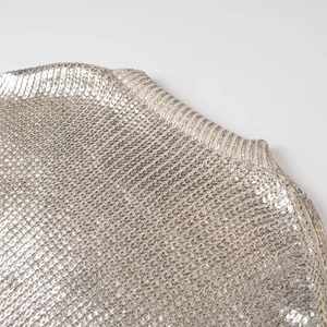 Close-up of metallic silver sequin knit fabric showing texture and crew neck detail