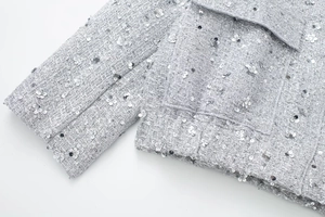 Detail of silver sequin flowers and tweed texture on a luxury women jacket