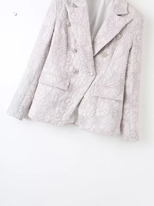Detailed view of pink jacquard blazer featuring double-breasted floral texture and silver buttons