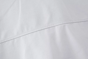 Détail macro du tissu en sergé diagonal et des coutures uniformes sur une chemise grise