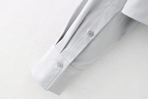Détail de la manchette à deux boutons sur une chemise polo courte grise chic