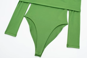 Detail showing high-stretch bright green bodysuit with snap closure and reinforced stitching