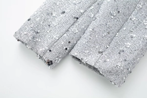 Detail of grey tweed jacket cuff featuring intricate silver sequin flower embroidery