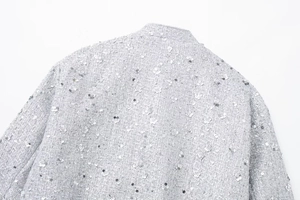 Detail of silver sequin embroidery on gray tweed fabric for luxury fashion jacket
