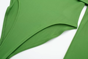 Detail view showing precision stitching and reinforced edges on green bodysuit