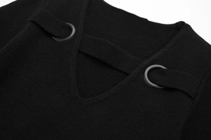 Detailed close-up of a black knit dress showing deep V-neckline with metal eyelets and lacing