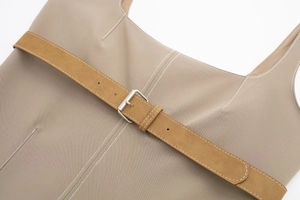 Detail of khaki jacket showing contrast stitching and suede belt with metal buckle