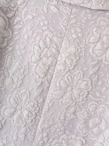 Close-up of elegant lavender jacquard fabric with textured 3D floral pattern for suit