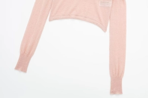 Detail of pink semi-transparent long sleeve knit top with ribbed cuffs and sheer texture