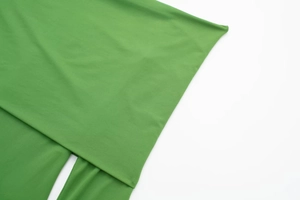 Detailed macro view of vibrant green elastic knit fabric with premium stitching craftsmanship