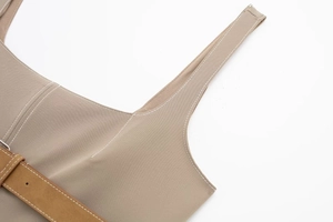 Detailed view of khaki twill top with white contrast stitching and brown suede belt
