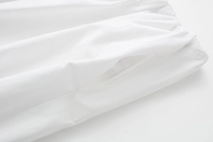 Détail de la taille élastique et de la poche latérale sur jupe midi blanche ample
