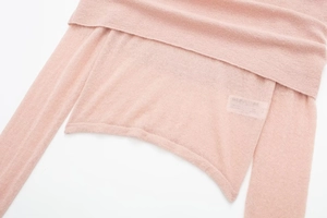 Detail of light pink sheer knit top showing asymmetrical layered collar and soft texture