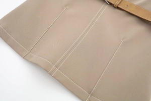 Detail of khaki twill fabric with white contrast stitching and a brown leather belt
