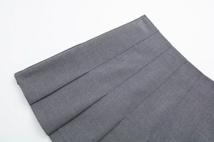 Detail view of the high-quality woven grey pleated skirt showing neat wide pleat stitching