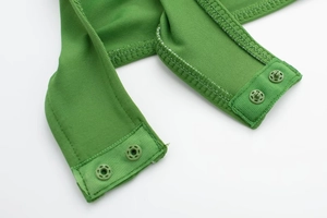 Close-up of green knit bodysuit showing durable snap button closure and fine stitching
