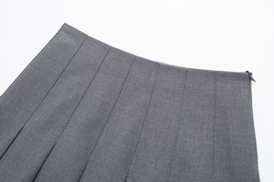 Detailed view of dark grey pleated skirt showing seamless hidden zipper and waistline