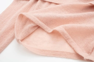 Detailed macro view of soft pink knit fabric texture and fine ribbed hem finishing
