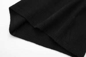 Detailed close-up showing the ribbed hem texture and fine knit of the black dress