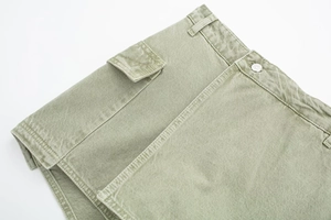 Détail de la jupe-short cargo vert olive avec bouton argenté et poche à rabat 3D